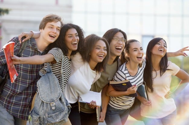 Grupo multiétnico de jovens estudantes felizes em pé ao ar livre Foto gratuita