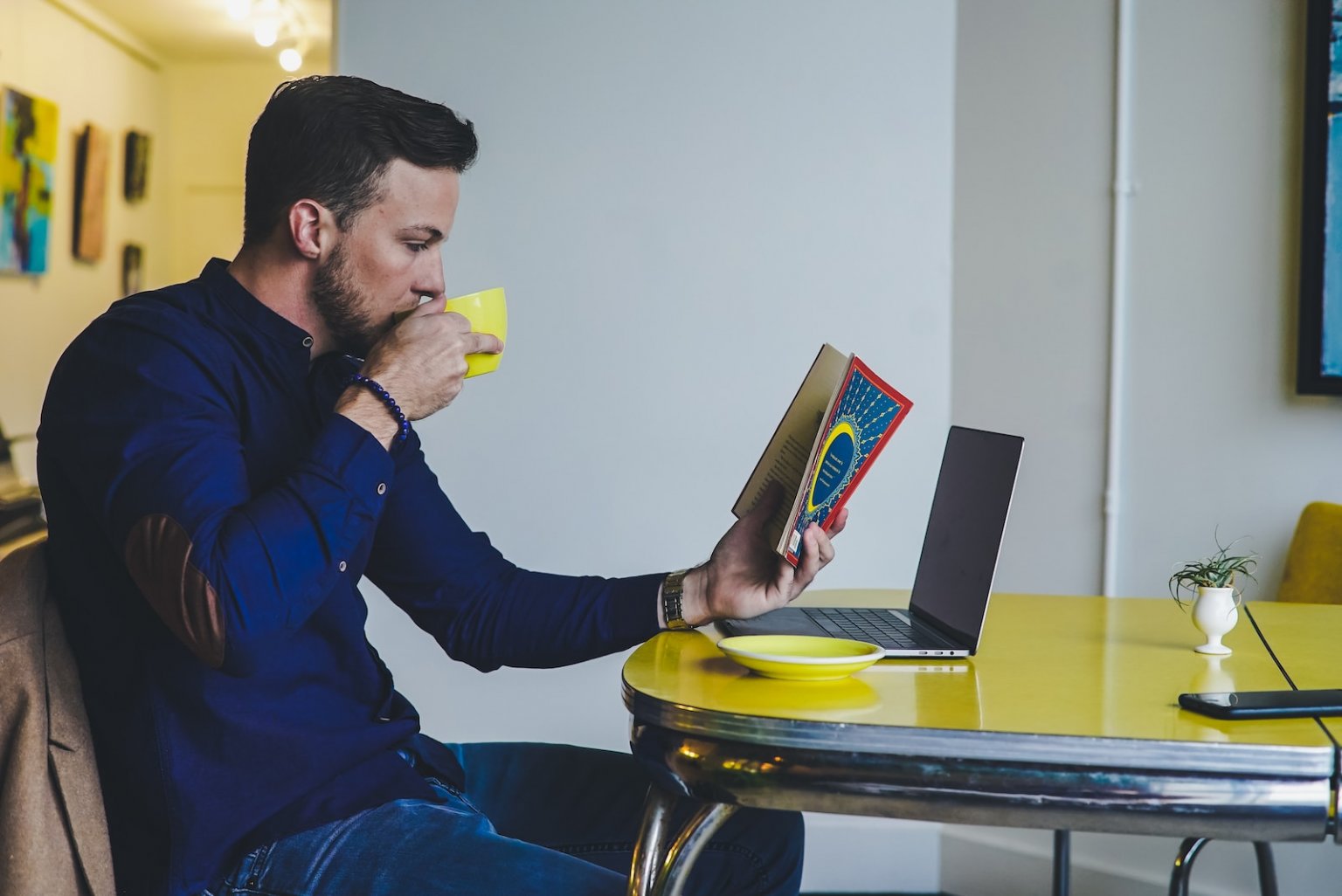 Curso de Inglês com Intercâmbio: Veja com encontrar! person reading book while drinking beverage